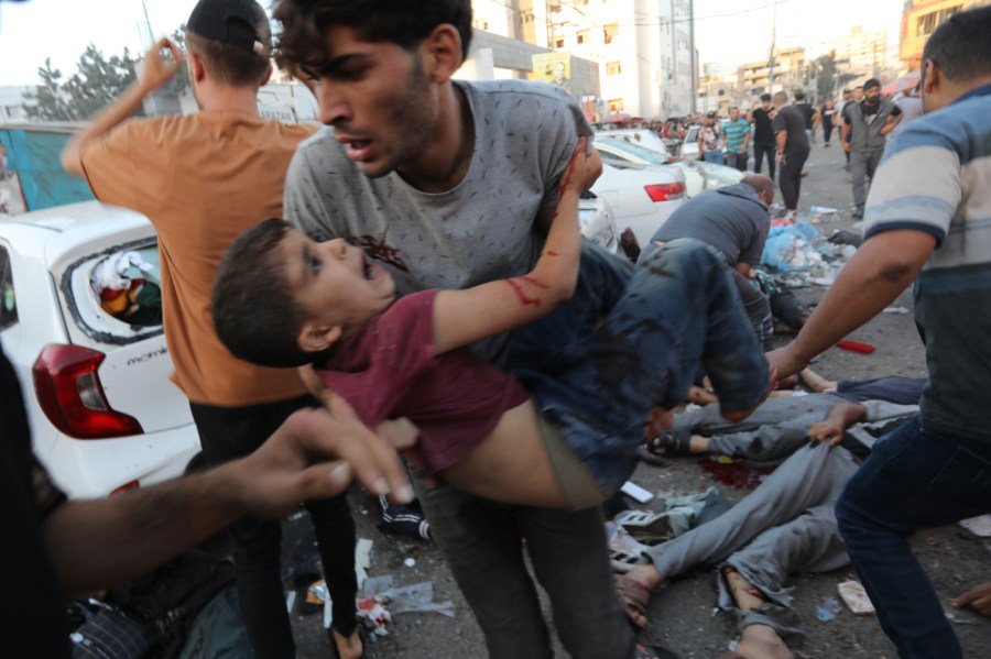 An injured Palestinian boy is carried from the ground following an Israeli airstrike outside the entrance of the al-Shifa hospital in Gaza City, Friday, Nov. 3, 2023.