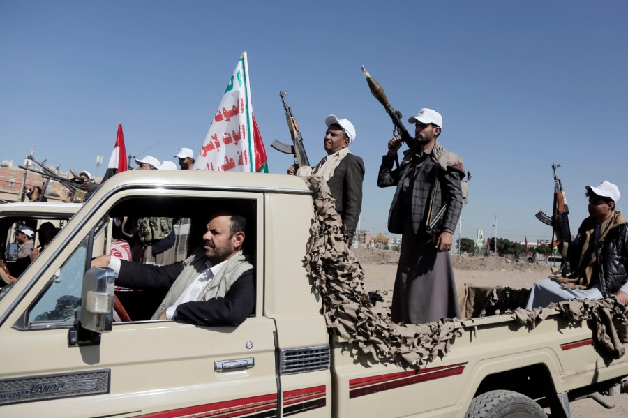 Yemen's Houthi followers holding their weapons ride vehicles as they participate in a rally and parade staged against Israeli and its allies USA and UK for their support to the Israeli continuing war on the Gaza Strip, on February 22, 2024, in Sana'a, Yemen.