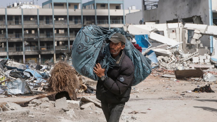 A Palestinian carries his belongings after visiting their houses destroyed in the Israeli offensive on Khan Younis, Gaza Strip, Wednesday, March 6, 2024.