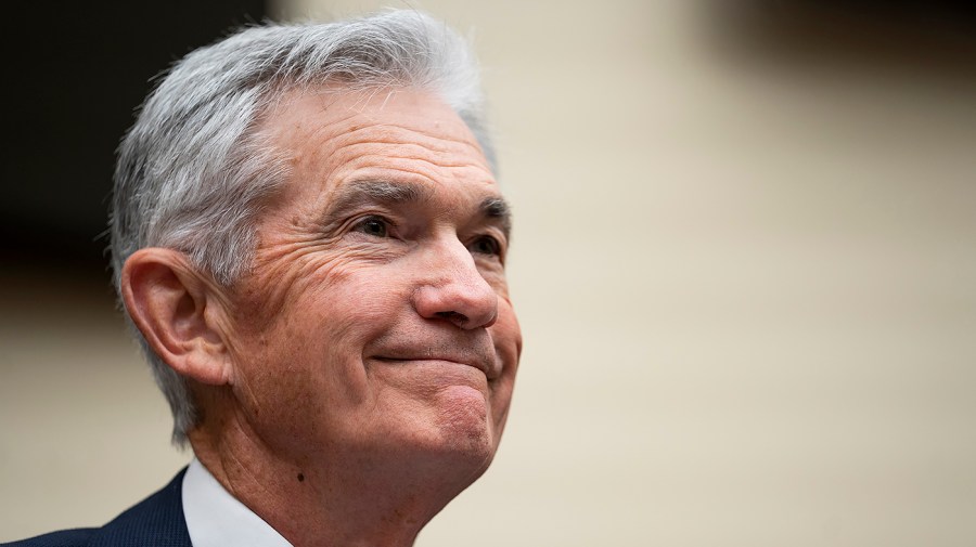 Federal Reserve Chair Jerome Powell smiles at a hearing.