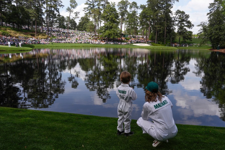Peter Malnati's son Hatcher and wife Alicia, watch on the ninth hole during the par-3 contest at the Masters golf tournament at Augusta National Golf Club Wednesday, April 10, 2024, in Augusta, GA. (AP Photo/Charlie Riedel)