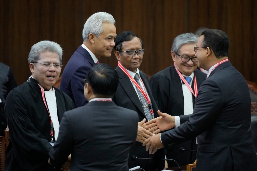 Presidential candidate Ganjar Pranowo, second left, his running mate Mahfud MD, third left, their lawyer Todung Mulya Lubis, left, greet presidential candidate Anies Baswedan, right, and his running mate Muhaimin Iskandar upon their arrival at the Constitutional Court in Jakarta, Indonesia, Monday, April 22, 2024. The country's top court on Monday rejected appeals lodged by two losing presidential candidates who are demanding a revote, alleging widespread irregularities and fraud at the February polls. (AP Photo/Dita Alangkara)