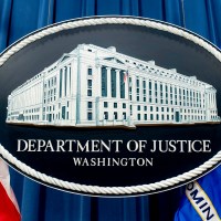FILE - The seal for the Justice Department is photographed in Washington, Nov. 18, 2022. The Justice Department has announced three arrests in a complex stolen identity scheme that officials say generates enormous proceeds for the North Korean government, including for its weapons program. (AP Photo/Andrew Harnik, File)