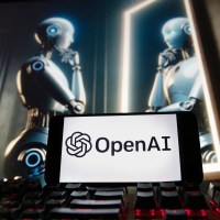 FILE - The OpenAI logo is seen displayed on a cell phone with an image on a computer monitor generated by ChatGPT's Dall-E text-to-image model, Friday, Dec. 8, 2023, in Boston. A former OpenAI leader who resigned from the company earlier this week said on Friday that product safety has "taken a backseat to shiny products" at the influential artificial intelligence company. (AP Photo/Michael Dwyer, file)