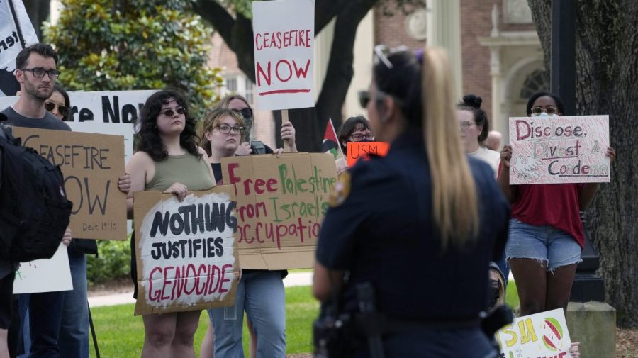 A group of students hold signs during a campus protest.