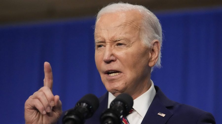 President Biden points up while speaking at an event.