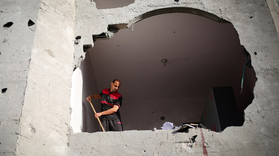 Blood stains are visible on the wall as a man sweeps rubble in a building hit by Israeli bombing in Rafah in the southern Gaza Strip on May 3, 2024, amid the ongoing conflict between Israel and the Hamas movement.