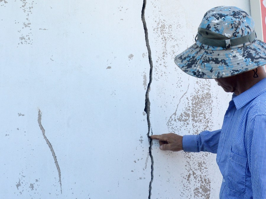 A resident points a cracked wall at a home damaged by an earthquake in Buan, South Korea, Wednesday, June 12, 2024. An earthquake broke windows and caused other minor damage in a fishing community in southwestern South Korea on Wednesday, but no injuries have been reported. (Kim Eul/Newsis via AP)