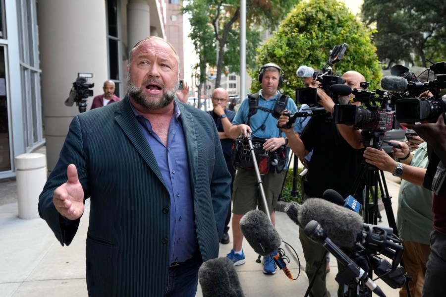 Right-wing conspiracy theorist Alex Jones speaks to the media as he arrives at the federal courthouse for a hearing in front of a bankruptcy judge Friday, June 14, 2024, in Houston. The judge is expected to rule on whether to liquidate Jones' assets to help pay the $1.5 billion he owes for his false claims that the Sandy Hook Elementary School shooting was a hoax. (AP Photo/David J. Phillip)