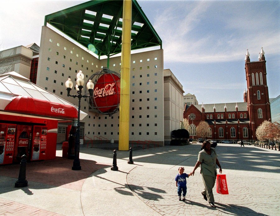 FILE - Emily Robinson and two-year-old Amari Peacock leave the plaza outside the original World of Coca-Cola museum in downtown Atlanta Tuesday, March 2, 1999. The Coca-Cola Co. moved the museum to a different downtown Atlanta site in 2007 and Georgia state government is in the process of demolishing the original building for parking as of Friday, June 14, 2024. (AP Photo/Ric Feld. File)