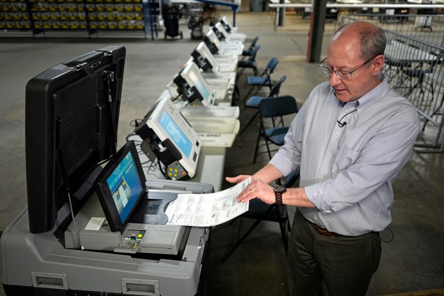 FILE - Allegheny County election division manager David Voye demonstrates a voting machine used to process paper ballots at polling places at the elections warehouse in Pittsburgh, April 18, 2024. Pennsylvania is seeing lots of action targeting gaps in its vote-by-mails laws. The problem is that it's in the courtroom and not the Legislature. (AP Photo/Gene J. Puskar, File)