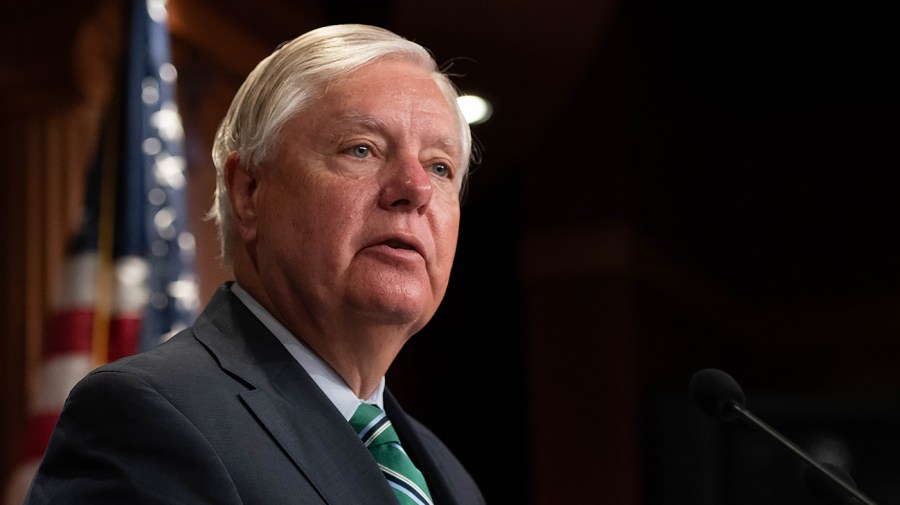 Senator Lindsey Graham listens during a press conference.