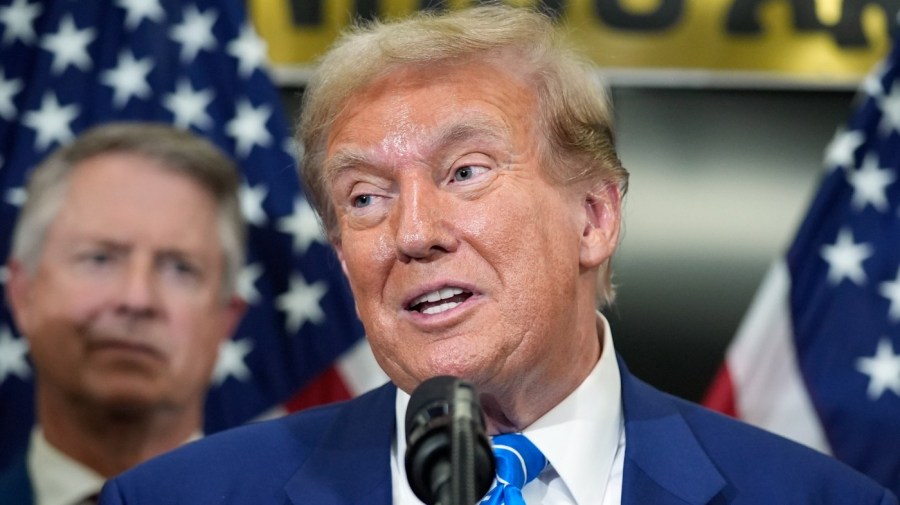 Former President Trump speaks in front of American flags.