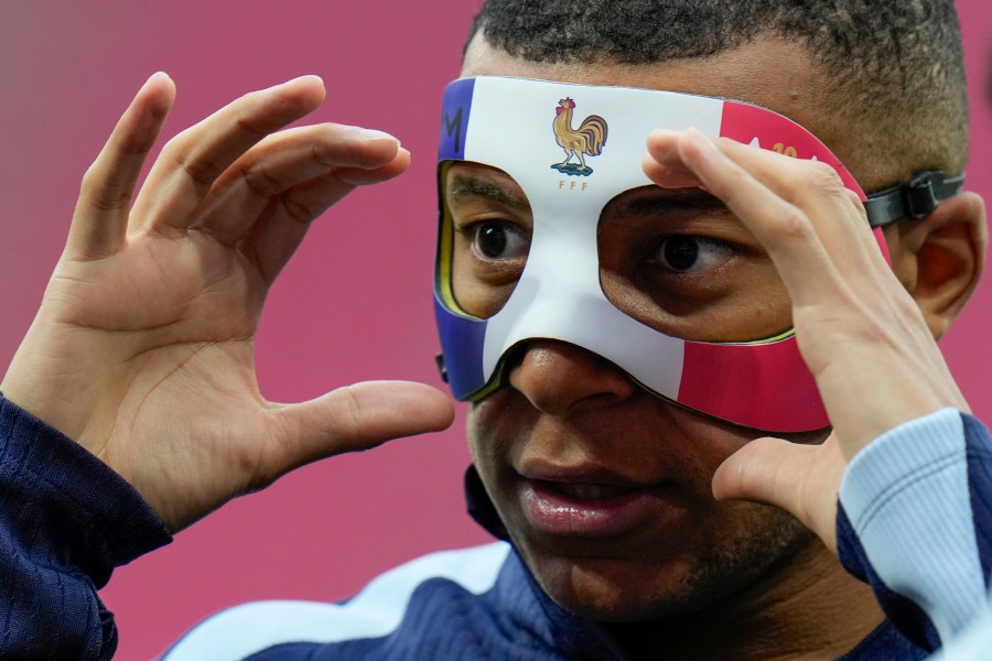 FILE - France's Kylian Mbappe adjusts his face mask during a training session in Leipzig, Germany, on June 20, 2024. Kylian Mbappé has had more masks than goals at Euro 2024. Widely regarded as the heir to Lionel Messi and Cristiano Ronaldo as soccer's biggest icon, the France striker is struggling with his peripheral vision due to the protective face covering he has been fitted with since breaking his nose at the start of the European Championship. (AP Photo/Hassan Ammar)