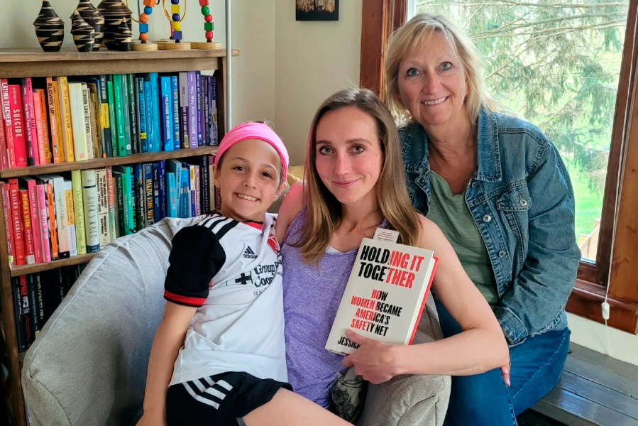 Jessica Calarco, center, poses with her daughter, Layla Calarco, and mother, Anne McCrory, in this undated photo provided by Jessica Calarco. Calarco is holding a copy of her book, "Holding It Together: How Women Became America's Safety Net." (Jessica Calarco via AP)