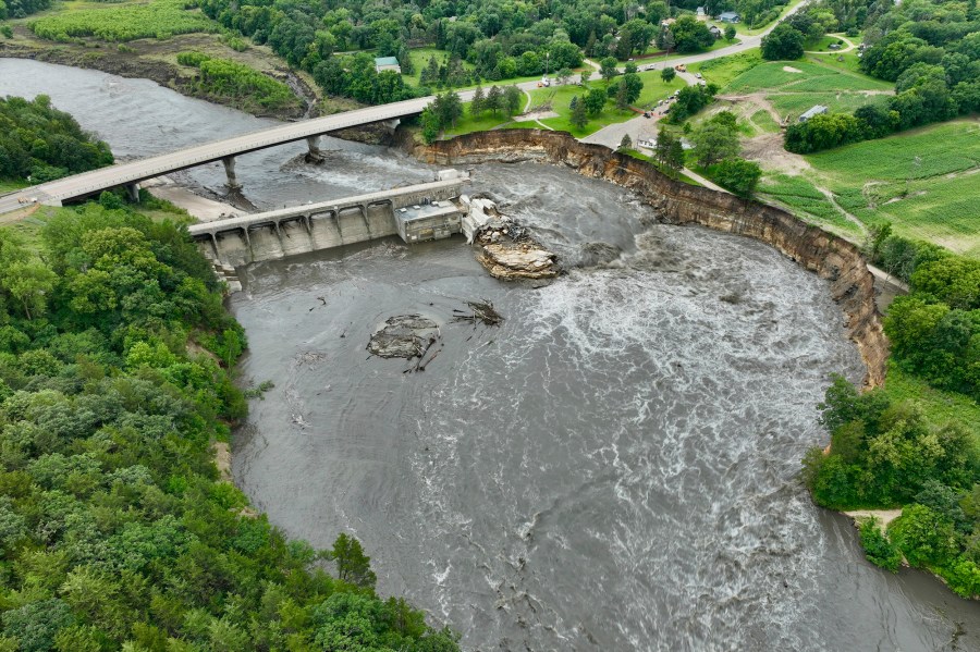 Floodwater continues to carve a channel around the Rapidan Dam, Thursday, June 27, 2024, near Mankato, Minn. Water breached the earthen abutment early Monday morning and rapidly eroded the west bank of the Blue Earth River. (AP Photo/Mark Vancleave)