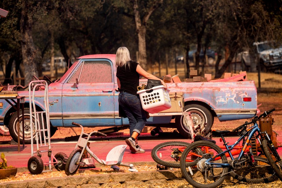 Cindy Miller moves belongings from her home as the Grubbs Fire burns in the Palermo community of Butte County, Calif., on Wednesday, July 3, 2024. (AP Photo/Noah Berger)