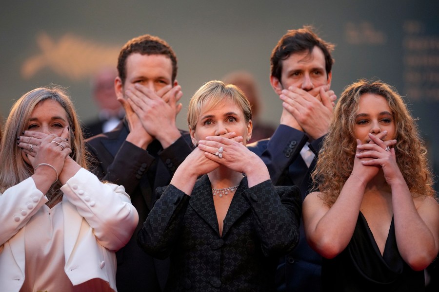 FILE "- Me Too" director Judith Godreche, center, poses with hands covering their mouth upon arrival at the premiere of the film 'Furiosa: A Mad Max Saga' at the 77th international film festival, Cannes, southern France, Wednesday, May 15, 2024. French film director Benoit Jacquot accused by multiple actors of sexual assault and violent, controlling behavior, including when his alleged victims were teenagers, has been handed preliminary charges of rape, sexual assault and violence by a French judge investigating the case, the Paris prosecutor's office said Thursday,July 4, 2024. Godrèche, who alleges that Jacquot raped and physical abused her in a six-year relationship that started when she was 14, has taken a lead role in kickstarting the #MeToo wave, which struggled for traction before she spoke out and emboldened other actors to do so, too. (Photo by Andreea Alexandru/Invision/AP, File)