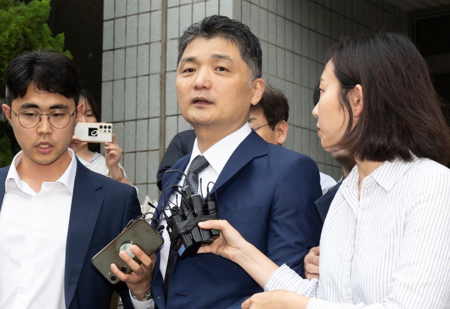 Kim Beom-su, center, the founder of the country's tech giant Kakao Corp., leaves a courtroom after a warrant hearing at the Seoul Southern District Court in Seoul, South Korea, Monday, July 22, 2024. (Yoon Dong-jin/Yonhap via AP)