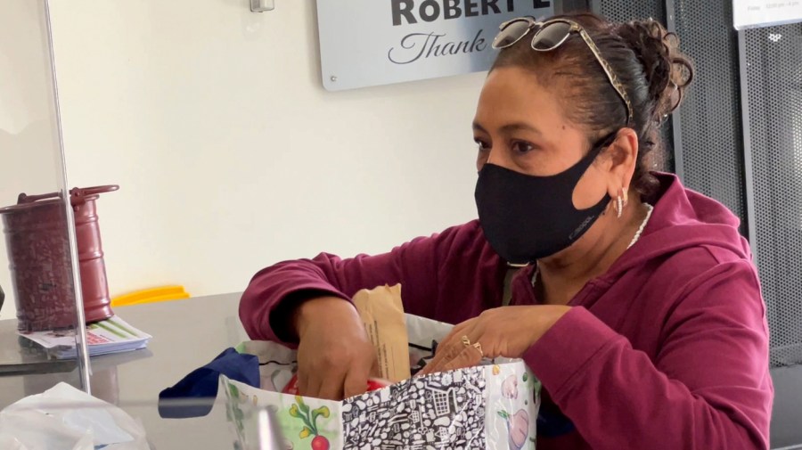 Ita Espinoza, a restaurant cook, picks up free groceries for her family from a food pantry at Shiloh Mercy House in Oakland, Calif., on Nov. 5, 2021. U.S. food banks dealing with increased demand from families sidelined by the pandemic now face a new challenge – surging food prices and supply chain issues. As holidays approach, some food banks worry they won't have enough turkeys, stuffing and cranberry sauce for Thanksgiving and Christmas. Residents picking up free groceries in Oakland said they're grateful for the extra help as the price of dairy, meat and fuel has shot up. (AP Photo/Terry Chea)