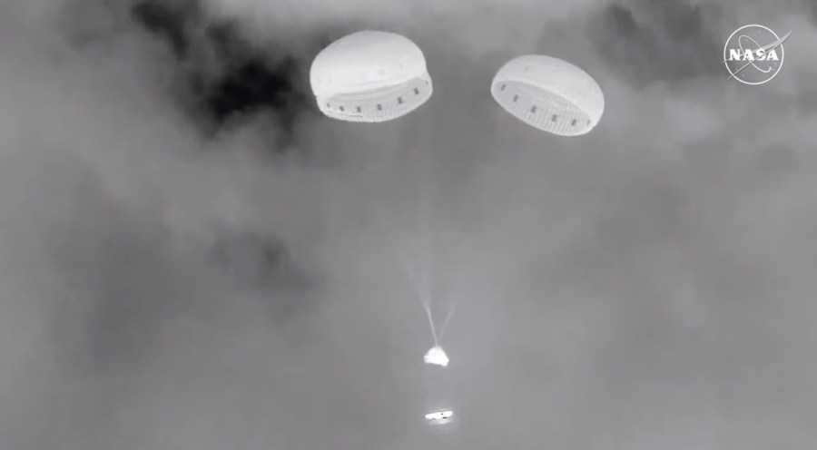 In this image from video provided by NASA, the empty Boeing Starliner capsule jettisons its heat shield, bottom, before touching down at White Sands Missile Range in New Mexico late Friday, Sept. 6, 2024, after undocking from the International Space Station. (NASA via AP)