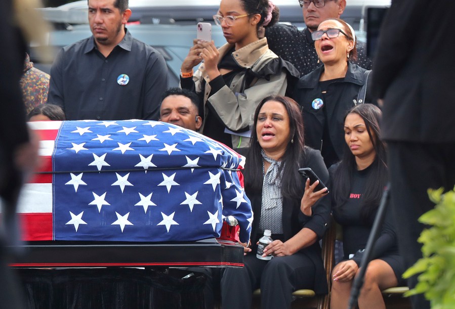 Sandra Garcia, center, sits with other family members as pallbearers carry the casket of her son, Massachusetts State Police recruit Enrique Delgado-Garcia, during his funeral service at the Mercadante Funeral Home in Worcester, Mass., Saturday, Sept. 24, 2024. (John Tlumacki/The Boston Globe via AP)