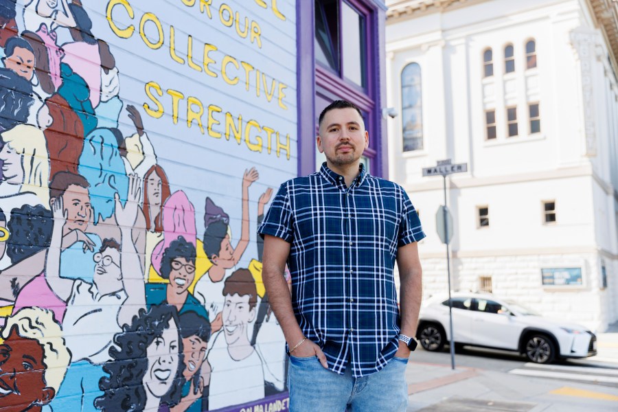 Luis A. Torres stands for a portrait in front of the " Joy is the Fuel" mural by Cuban-American artist Alma Landeta at the SF LGBT Center on Friday, Sept. 20, 2024, in San Francisco. (AP Photo/Juliana Yamada)