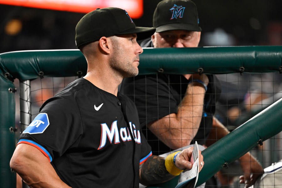 Miami Marlins manager Skip Schumaker, left, listens to Marlins pitching coach Mel Stottlemyre, right, in the dugout during the sixth inning of a baseball game against the Washington Nationals, Thursday, Sept. 12, 2024, in Washington. (AP Photo/John McDonnell)