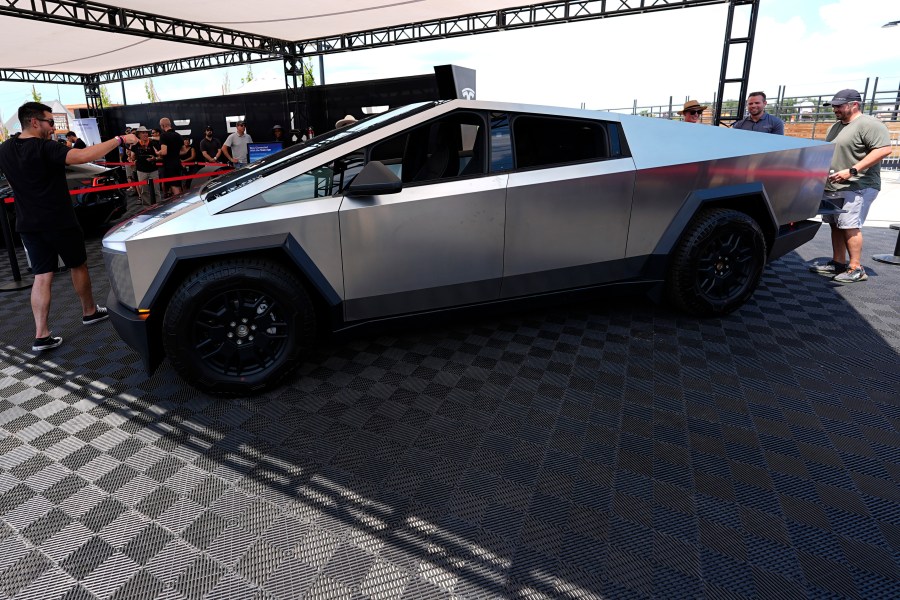 FILE - Visitors look over a 2024 Cybertruck in the Tesla display at the Electrify Expo, July 14, 2024, in north Denver. (AP Photo/David Zalubowski, File)