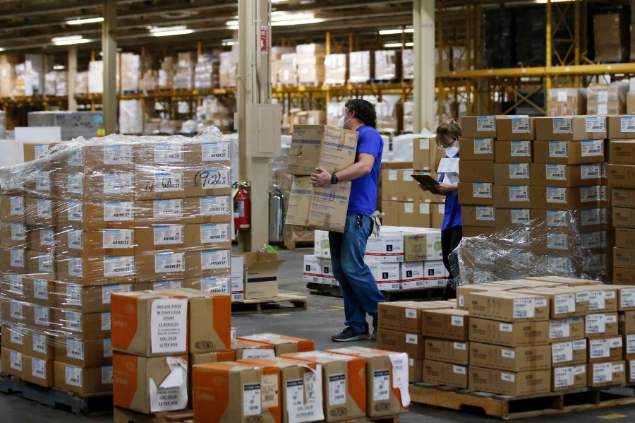 FILE - Workers carry boxes at a Strategic National Stockpile warehouse in Oklahoma City, Okla., April 7, 2020. (AP Photo/Sue Ogrocki, File)