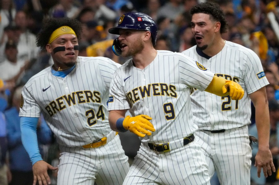 Milwaukee Brewers' Jake Bauers celebrates his home run with William Contreras (24) and Willy Adames (27) during the seventh inning of Game 3 of a National League wild card baseball game against the New York Mets Thursday, Oct. 3, 2024, in Milwaukee. (AP Photo/Morry Gash)