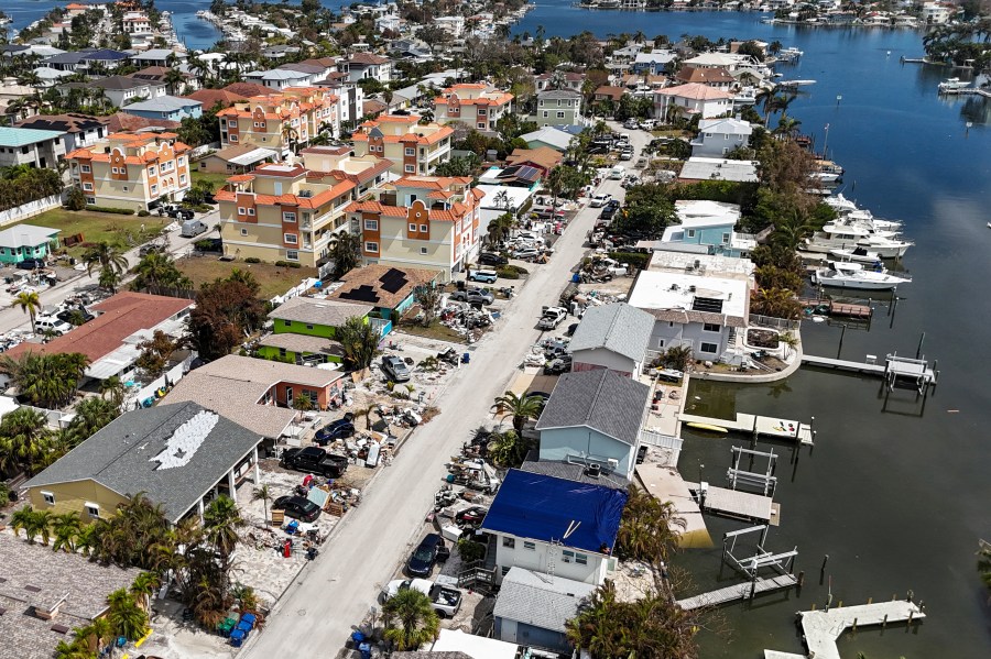 Contents of homes line the streets after flooding from Hurricane Helene on Wednesday, Oct. 2, 2024, in Reddington Shores, Fla. (AP Photo/Mike Carlson)