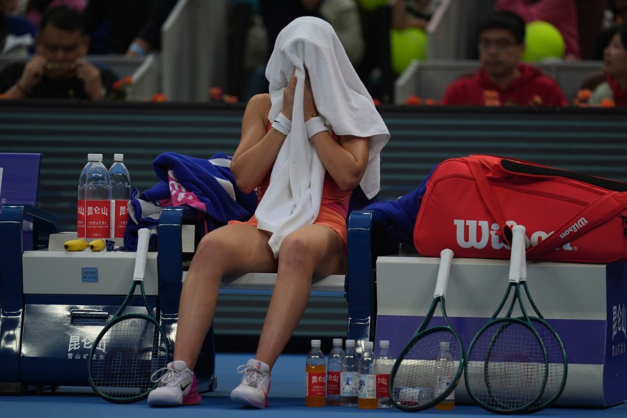 Paula Badosa of Spain cover herself with a towel during sets against Coco Gauff of the United States in a women's singles semi-final match for the China Open tennis tournament held at the National Tennis Center in Beijing, Saturday, Oct. 5, 2024. (AP Photo/Ng Han Guan)