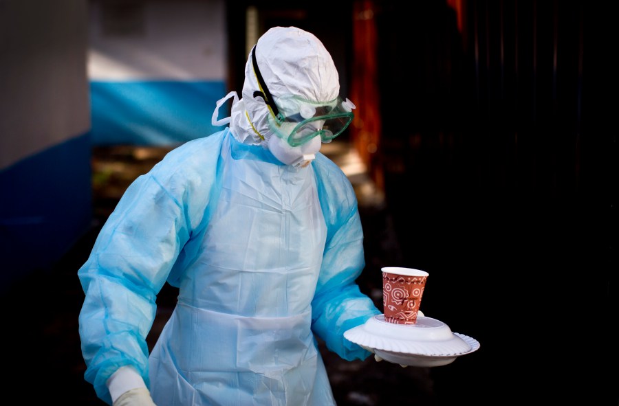 FILE - In this Oct. 8, 2014 photo, a medical worker from the Infection Prevention and Control unit wearing full protective equipment carries a meal to an isolation tent housing a man being quarantined after coming into contact in Uganda with a carrier of the Marburg Virus, at the Kenyatta National Hospital in Nairobi, Kenya. (AP Photo/Ben Curtis, File)