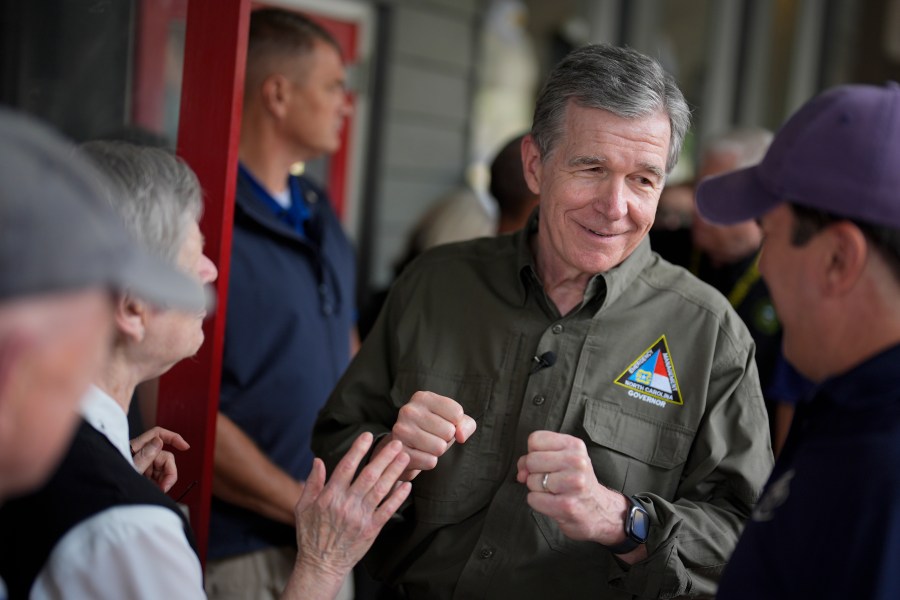 North Carolina governor Roy Cooper greets people on Thursday, Oct. 3, 2024, in Boone, N.C. in the aftermath of hurricane Helene. In the final weeks of the presidential election, people in North Carolina and Georgia, influential swing states, are dealing with more immediate concerns: recovering from Hurricane Helene. (AP Photo/Chris Carlson)