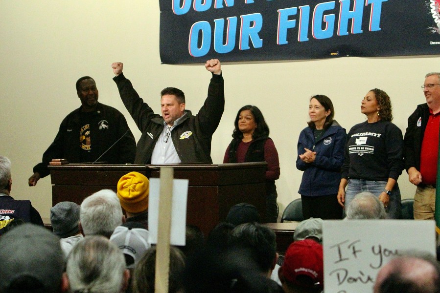 Jon Holden, IAM District 751 President, raises his arms as Sen. Maria Cantwell, D-Wash., Rep. Pramila Jayapal, D-Wash., and labor leaders stand behind him at a rally for Boeing union machinists, Tuesday, Oct. 15, 2024, in Seattle. (AP Photo/Manuel Valdes)