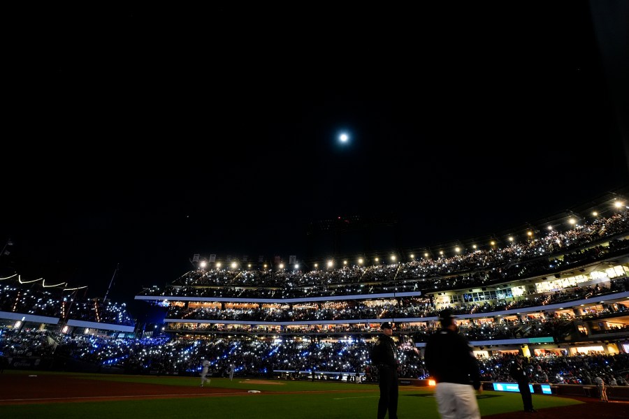 Fans light up the stadium during the third inning in Game 3 of a baseball NL Championship Series between the Los Angeles Dodgers and the New York Mets, Wednesday, Oct. 16, 2024, in New York. (AP Photo/Frank Franklin II)