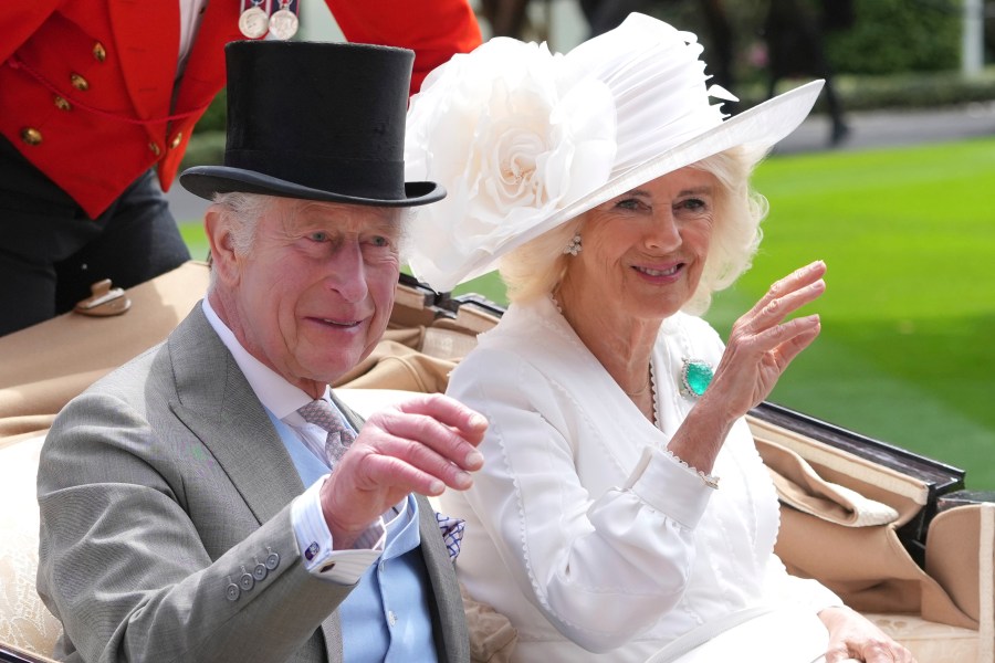 FILE - Britain's King Charles III and Queen Camilla wave to the crowds as they arrive by carriage in the parade ring on the third day of the Royal Ascot, horse race meeting, traditional known as Ladies Day, at Ascot, England, on June 20, 2024. (AP Photo/Kin Cheung, File)