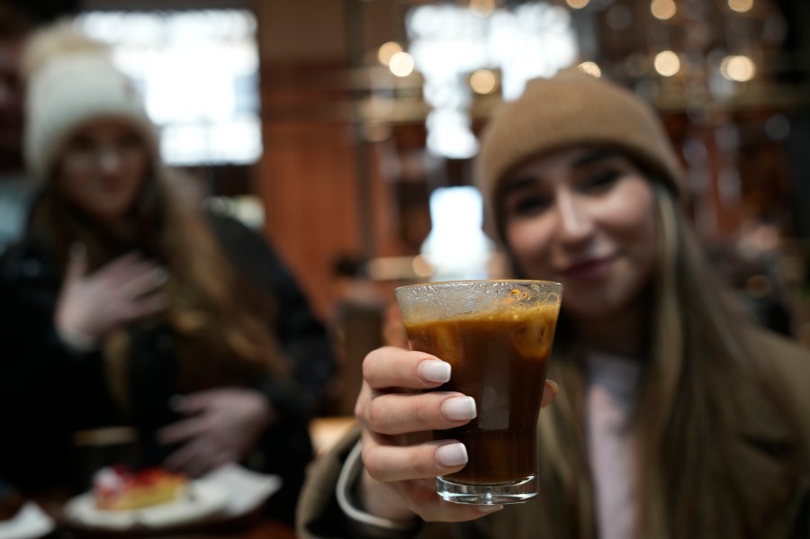 FILE - Kaya Cupial, right, shows her Oleato Iced Cortado coffee at the Starbucks coffee shop in Milan, Italy, Feb. 27, 2023. (AP Photo/Antonio Calanni, File)