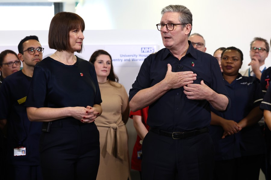 El primer ministro británico, Keir Starmer, y la ministra de Hacienda, Rachel Reeves, hablan con miembros del personal en una visita al Hospital Universitario de Coventry y Warwickshire, en Coventry, Inglaterra, el jueves 31 de octubre de 2024. (AP Foto/Darren Staples, pool)