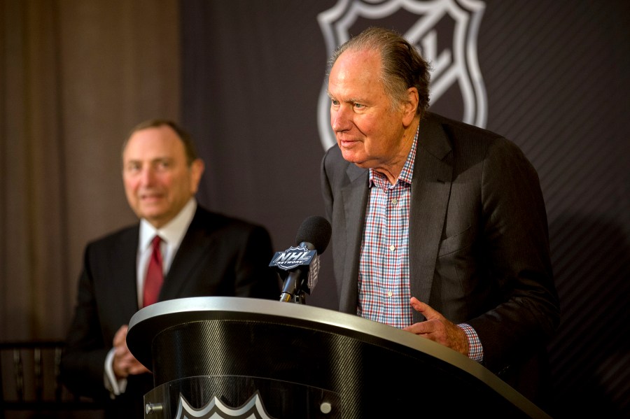 FILE - Seattle Kraken founding owner David Bonderman, right, steps up to the podium after the National Hockey League Commissioner Gary Bettman, left, named Seattle as the league's 32nd franchise, Dec. 4, 2018, in Sea Island, Ga. (AP Photo/Stephen B. Morton, File)